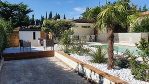 A backyard with a pool, outdoor seating, and a wooden deck. - Bastide des Tilleuls, a quiet and shaded retreat between Saint-Rémy-de-Provence and Avignon (Noves)