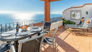 Eine Terrasse mit Tisch für zwei Personen, mit Blick aufs Meer.