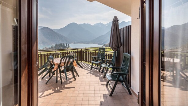 A balcony with chairs and a table, overlooking a lake and mountains. - Apartment "Bellavista" with Lake Views & Terrace (Mezzolago)