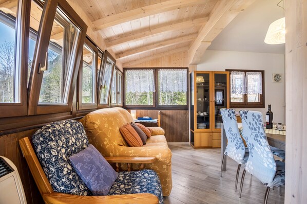 A wooden interior with a sofa, chairs, and a dining area.