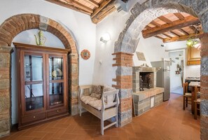 Una cucina rustica con un camino in pietra, pensili in legno e un'area pranzo.