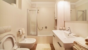 Et moderne badeværelse med toilet, bidet, badekar og vask.