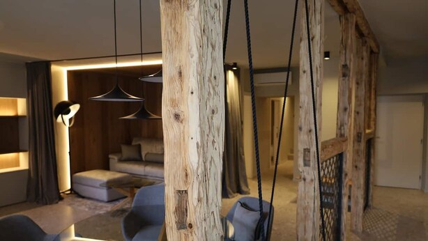 Un intérieur moderne avec un mur d’accent en bois, un canapé et un luminaire suspendu.
