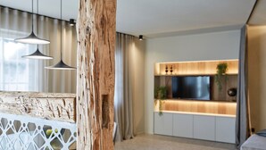 Une cuisine moderne dotée d’un éclairage suspendu, d’un mur d’accent en bois et d’un téléviseur encastré.