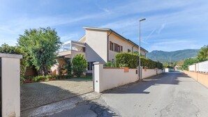 Una strada residenziale con case, una strada asfaltata e una montagna sullo sfondo.