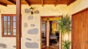 Un bâtiment en pierre avec une porte en bois, une fenêtre et un escalier menant à l’intérieur.