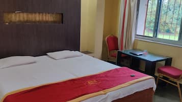 A hotel room with a bed, a desk, and a chair.