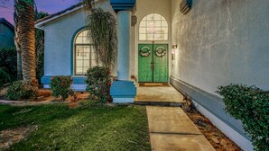 A house with a green door, a large arched window, and a small porch. - Terra Azul: Pool, Spa, Billiard Table, Foosball (Indio)