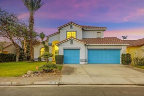 A two-story house with a garage, a driveway, and a well-maintained lawn. - Terra Azul: Pool, Spa, Billiard Table, Foosball (Indio)
