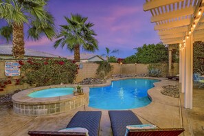 A backyard with a swimming pool, lounge chairs, and a pergola with string lights. - Terra Azul: Pool, Spa, Billiard Table, Foosball (Indio)