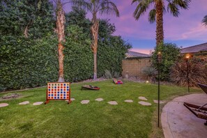 A backyard with a game board, a fire pit, and a patio area. - Terra Azul: Pool, Spa, Billiard Table, Foosball (Indio)