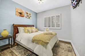 A bedroom with a bed, a nightstand, a lamp, and artwork on the wall. - Terra Azul: Pool, Spa, Billiard Table, Foosball (Indio)