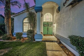 A house with a green door, a white porch, and a palm tree. - Terra Azul: Pool, Spa, Billiard Table, Foosball (Indio)
