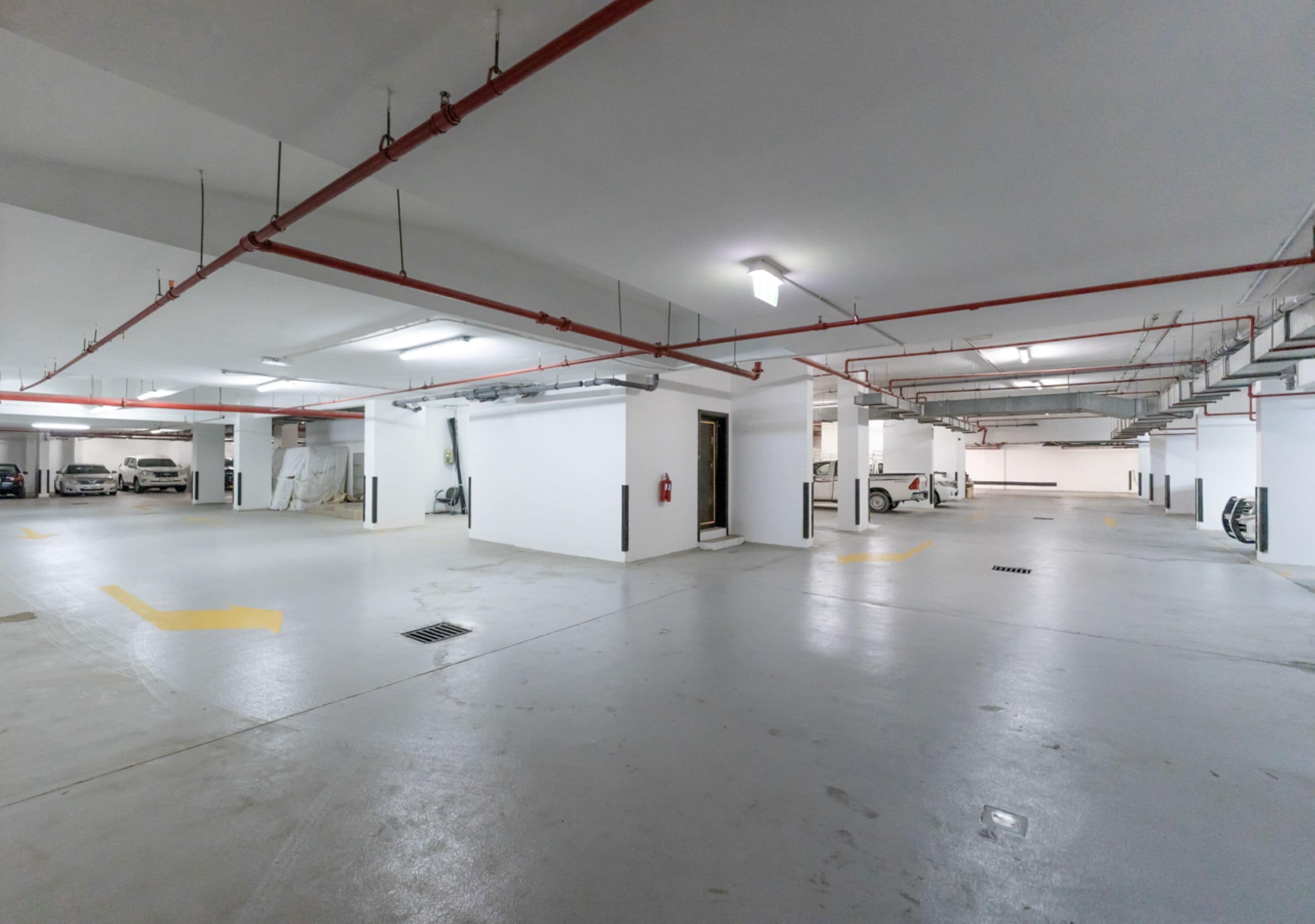A spacious indoor parking area with multiple levels, visible structural beams, and a clean, well-maintained floor.