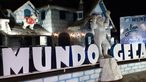 Een groot bord met de tekst 'MUNDO GELADO' en een gebouw met een blauw-witte gevel.