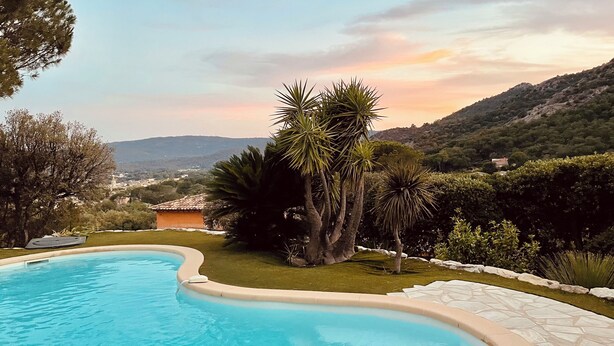 A swimming pool with a curved edge, surrounded by a stone deck and lush greenery, overlooking a scenic valley and distant hills. - VILLA DE CHARME, GOLFE St TROPEZ, AU CALME, BELLE VUE DEGAGEE, PISCINE CHAUFFEE (Le Plan-de-la-Tour)
