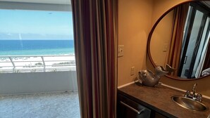 A bathroom with a view of the beach, a round mirror, and a sink. - Gulf Front Condo with Stunning Views! (Pensacola)