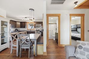 A compact kitchen with a dining area, a built-in oven, and a microwave.