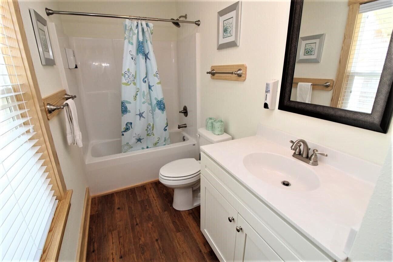 A bathroom with a bathtub, toilet, and sink.