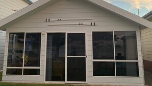 A single-story house with a gabled roof and large windows. - Family Friendly Shack with Bay Views (Fisherman bay)