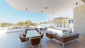 A modern outdoor patio with a pool, wicker furniture, and a view of the sea. - Periyiali Resort , Villa Melpomeni 21 at Konnos Beach - Cape Greco (Paralimni-Protaras)