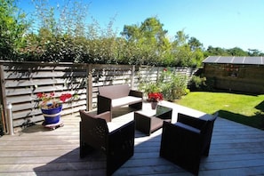 An outdoor patio with a wooden deck, wicker furniture, and potted plants. - Perfect villa with pool - fantastic location A3693 (Lège-Cap-Ferret)