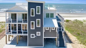 A beachfront property with a two-story main building and a separate structure with a balcony.