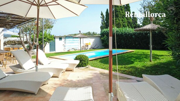 A poolside area with lounge chairs and umbrellas, a swimming pool, and a well-maintained garden. - Es Collet by Rentallorca (Manacor)