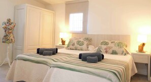 A bedroom with a bed, nightstands, a wardrobe, and a window. - Es Collet by Rentallorca (Manacor)