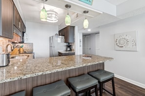 Enjoy cooking in this well-lit kitchen with a granite island and stainless steel appliances.