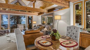 A spacious living area with a high ceiling, large windows, and a view of the outdoors. - Lake View 2BR/2BA Incline Village w/ Fireplace (Incline Village)