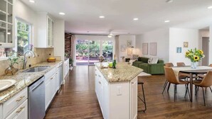 A modern kitchen with granite countertops, white cabinetry, and a central island.