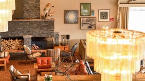 A cozy living room with a stone fireplace, comfortable seating, and artwork on the walls. - Ranten Hotell, BW Signature Collection (Nes)