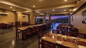 A spacious dining area with multiple tables and chairs, ceiling fans, and air conditioning units. - Mewar Palace Luxury Resort & Private Pool Villas - Udaipur (Udaipur)