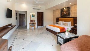 A hotel room with a bed, bedside table, chair, desk, and a TV. - Mewar Palace Luxury Resort & Private Pool Villas - Udaipur (Udaipur)