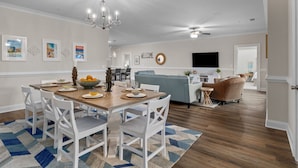 A spacious living area with a dining table set for four, a grey sofa, and a wicker chair. - Villa #706: 4  BR, 3  BA Condominium in Garden City, Sleeps 8 (Garden City)