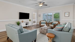 A living room with a flat-screen TV, two sofas, a coffee table, and a ceiling fan. - Villa #706: 4  BR, 3  BA Condominium in Garden City, Sleeps 8 (Garden City)
