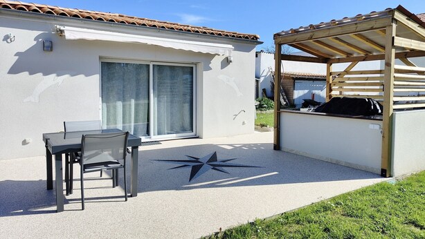 A patio area with a table and chairs, a covered seating area, and a star-shaped design on the ground.