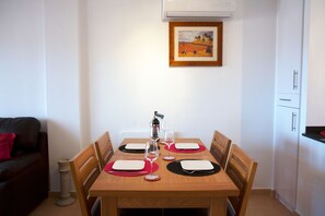 Une table à manger dressée avec des sets de table, des verres à vin et une bouteille.