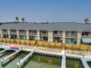 Un hôtel situé en bord de mer, doté de nombreux balcons, d’un espace piscine et d’un quai.