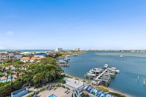 A coastal marina with boats docked, a beach area with umbrellas, and a clear view of the ocean. - ✈️ 🌊 South Harbour 6C: Blue Angels, Water Views + Walk to the Boardwalk! (Pensacola Beach)