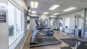 A gym with treadmills, weight machines, and a mirror.
