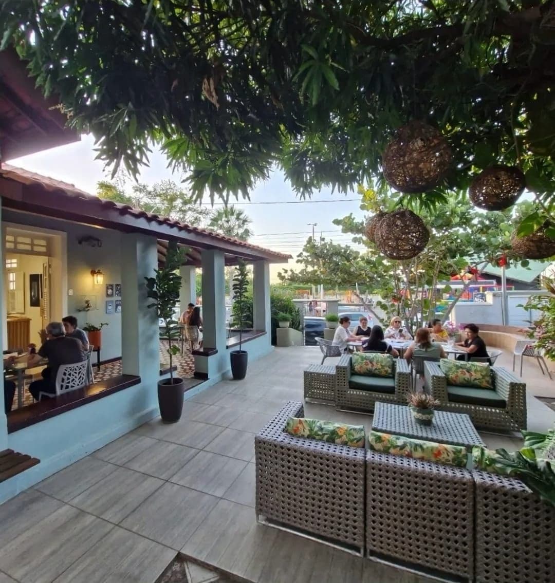 An outdoor seating area with wicker furniture and potted plants.