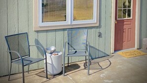 A building with a large window, a door, and two chairs outside. - Entire Studio Apartment - close to town BRAND NEW AC (Missoula)