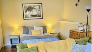 A cozy room with a bed, a green sofa, a small table, and a lamp. - Entire Studio Apartment - close to town BRAND NEW AC (Missoula)