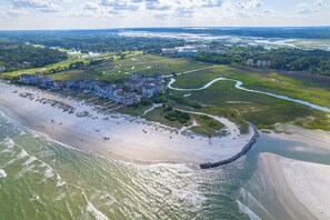 An aerial view of a coastal resort with beachfront properties, a golf course, and a river. - Family Villa • Sleeps 6 • Pools & Beach • 7-Min Walk • Hilton Head Island (Hilton Head Island)