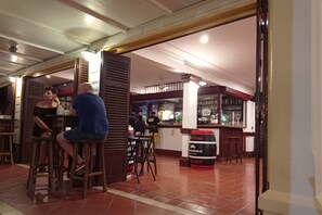 Enjoy a casual dining experience at our bar with a glass display case and comfortable seating.