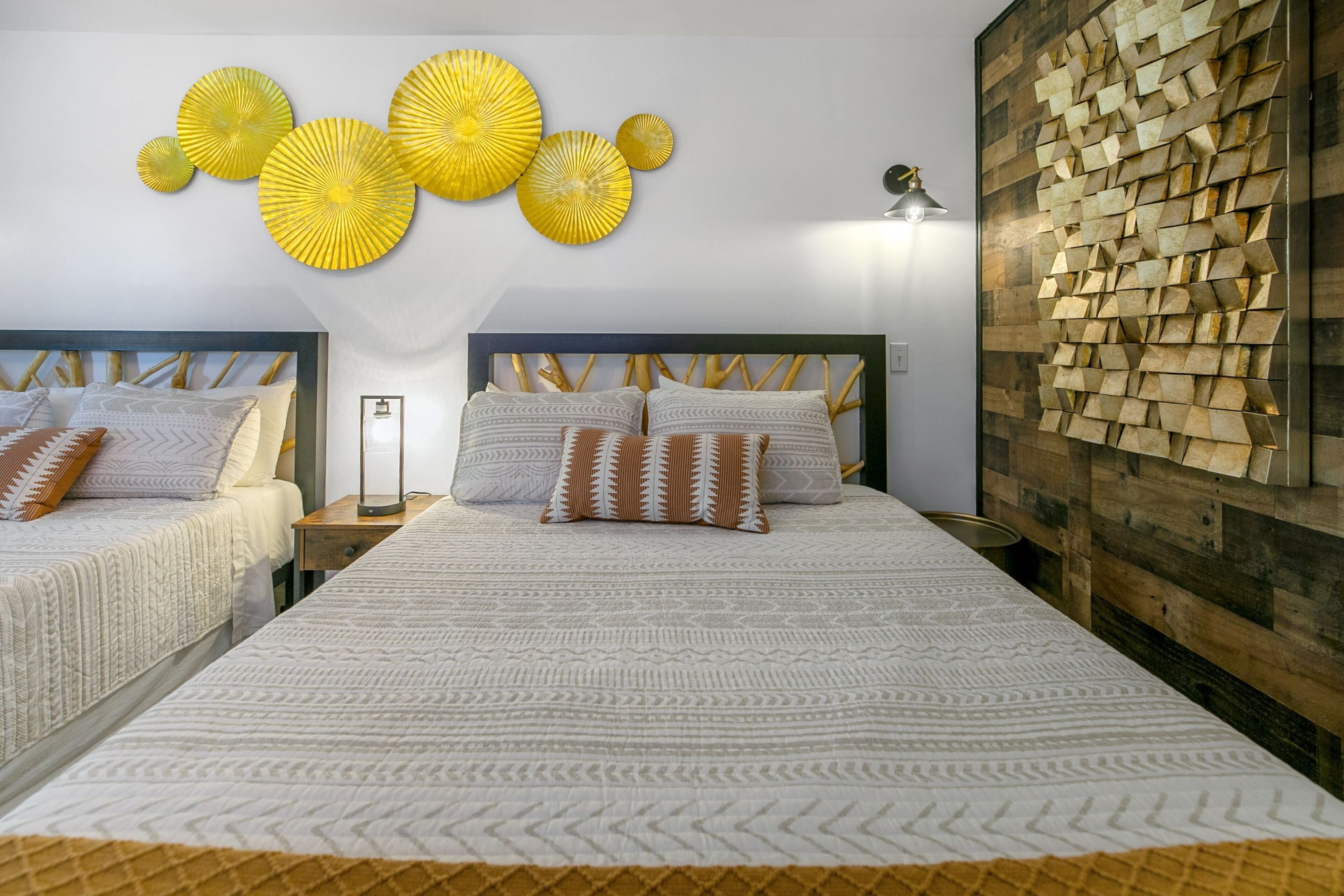 Ein Hotelzimmer mit zwei Betten, einer Holzvertäfelung und gelben Wanddekorationen.