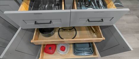 Un cajón de cocina con utensilios y utensilios de cocina.