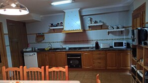 A compact kitchen with wooden cabinets, a microwave, a toaster, and a sink.